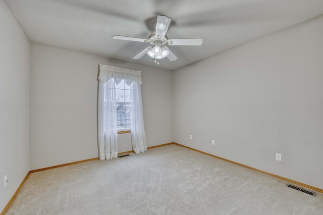 unfurnished room featuring light carpet and ceiling fan