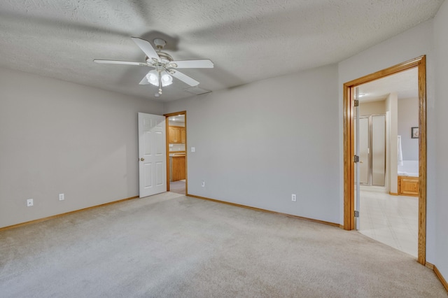 unfurnished bedroom with a textured ceiling, ceiling fan, ensuite bathroom, and light carpet