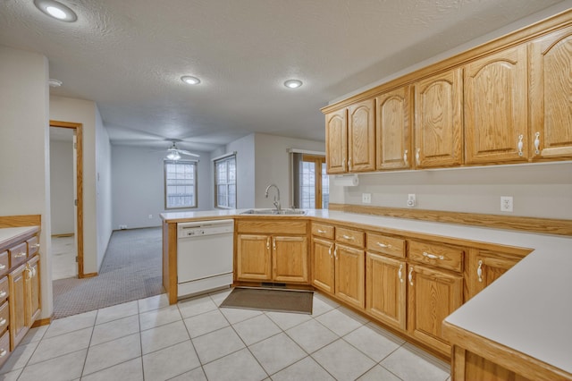 kitchen with dishwasher, sink, ceiling fan, light colored carpet, and kitchen peninsula