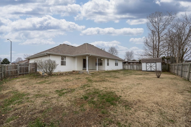 back of house with a storage shed and a lawn