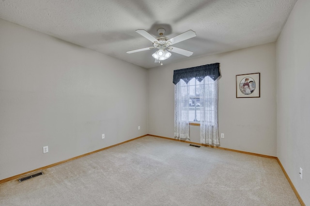 carpeted spare room featuring ceiling fan and a textured ceiling