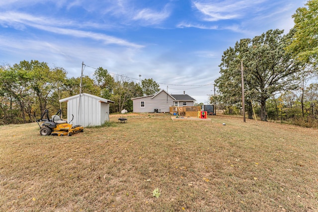 view of yard featuring a storage unit and a wooden deck