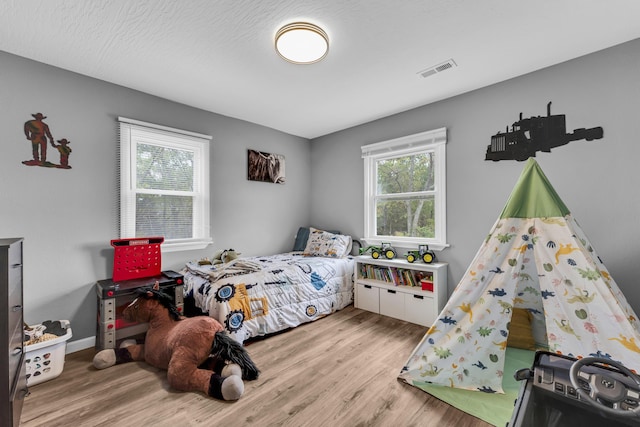 bedroom featuring light wood-type flooring and a textured ceiling