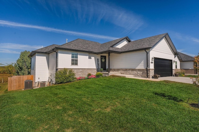 view of front of home with a front yard, a garage, and central air condition unit