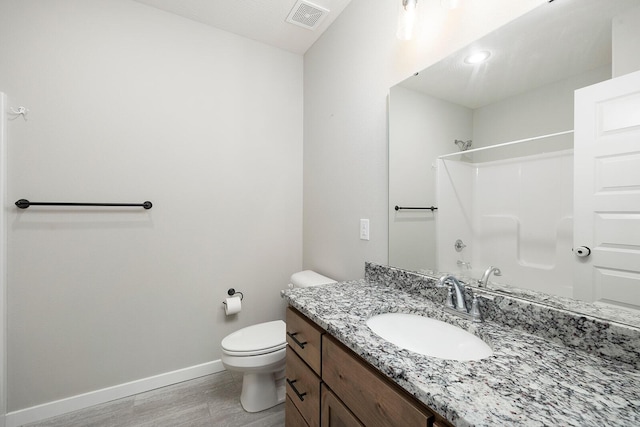 bathroom with hardwood / wood-style floors, vanity, toilet, and walk in shower