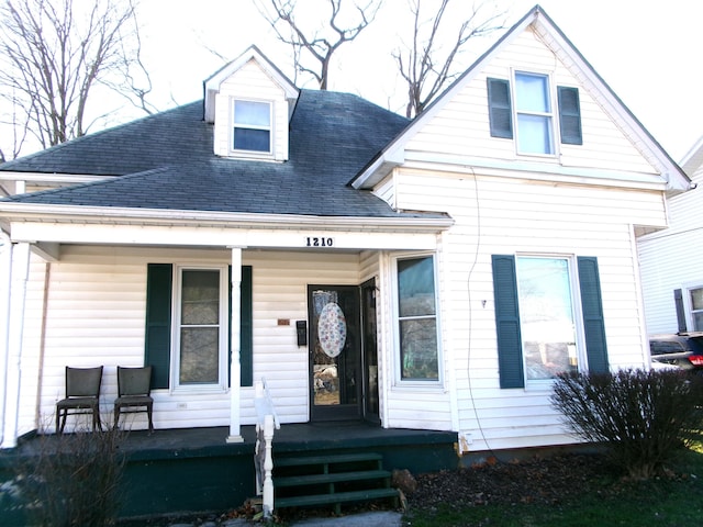 view of front facade featuring covered porch and roof with shingles