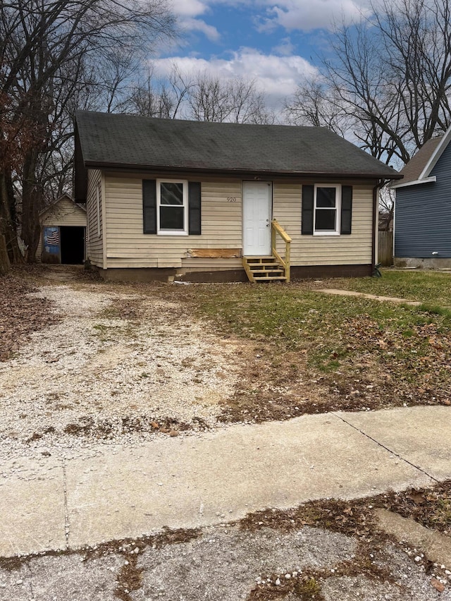 view of front of house with entry steps, driveway, and an outdoor structure