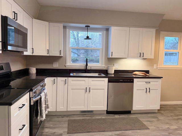 kitchen featuring pendant lighting, white cabinetry, sink, and stainless steel appliances