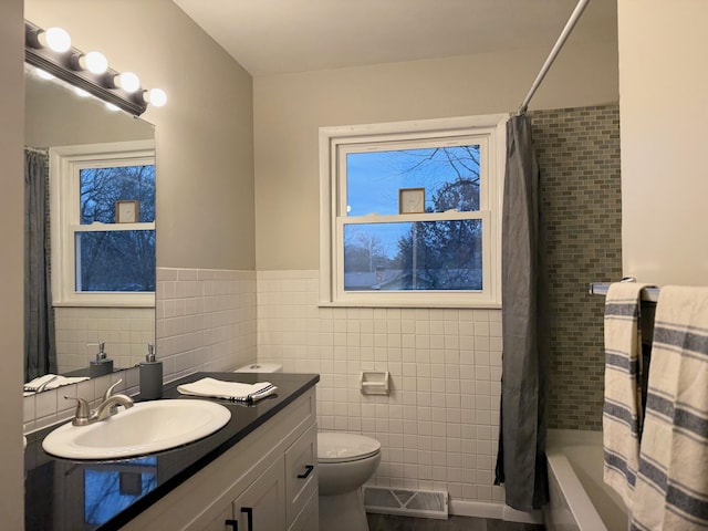 full bathroom featuring shower / bath combo, vanity, toilet, and tile walls