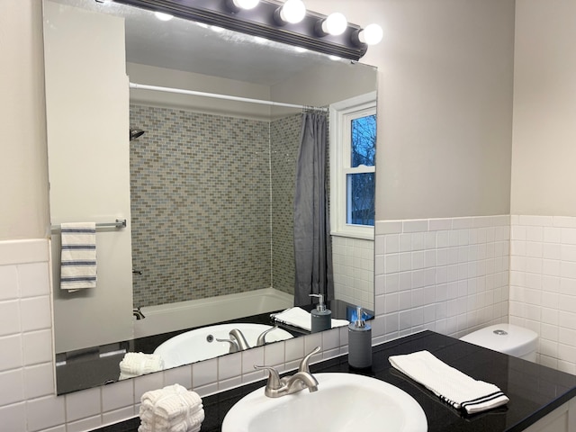 full bathroom with toilet, tile walls, shower / bathtub combination with curtain, and sink