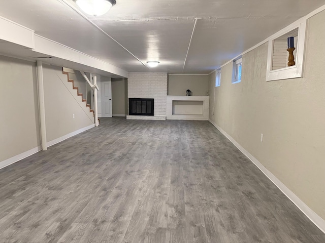 basement with hardwood / wood-style flooring and a brick fireplace