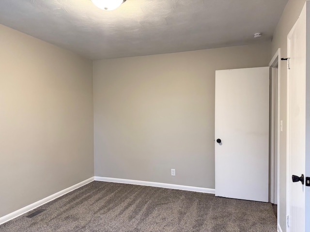 unfurnished room featuring dark carpet