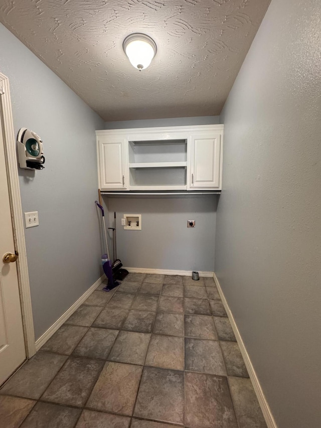 washroom with cabinets, hookup for a washing machine, and a textured ceiling