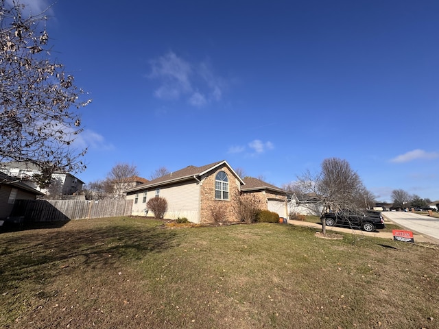 view of side of home featuring a garage and a lawn