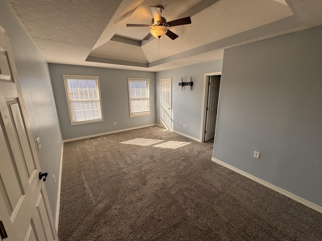 carpeted spare room featuring ceiling fan, a textured ceiling, and a tray ceiling