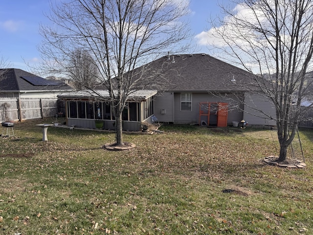 rear view of property featuring a sunroom and a yard