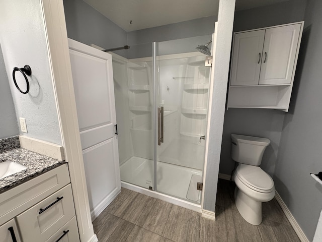 bathroom featuring vanity, toilet, and an enclosed shower