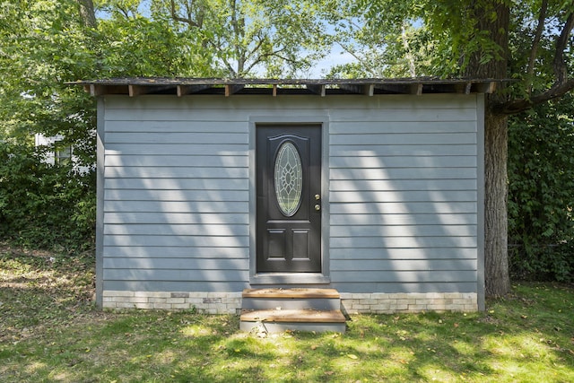 view of exterior entry featuring a yard