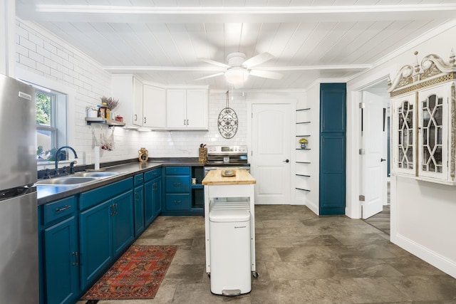 kitchen featuring wood counters, appliances with stainless steel finishes, blue cabinets, sink, and white cabinetry