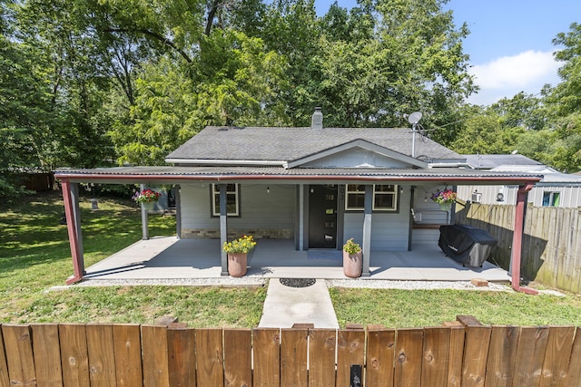 rear view of house with a lawn and a patio