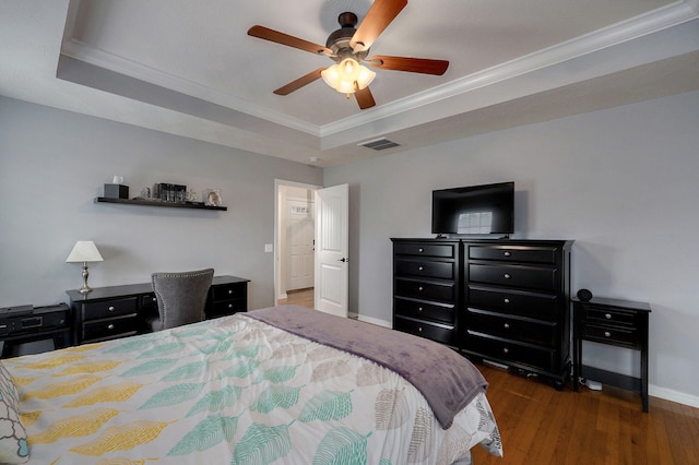 bedroom with a raised ceiling, dark hardwood / wood-style flooring, ceiling fan, and crown molding