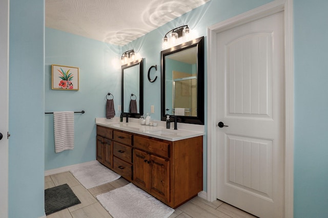 bathroom featuring tile patterned flooring, vanity, and walk in shower