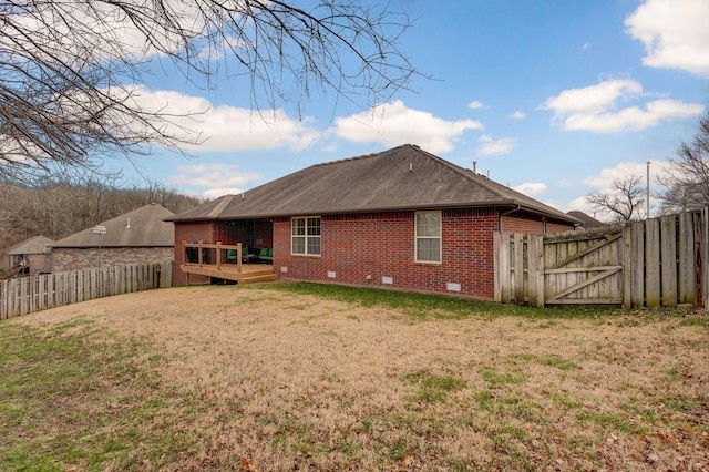 back of property with a yard and a deck