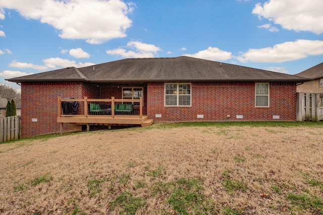 rear view of house featuring a lawn and a deck