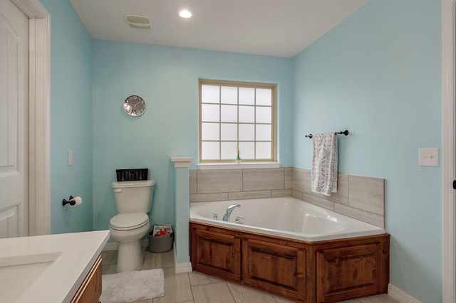 bathroom with tile patterned flooring, vanity, a tub to relax in, and toilet