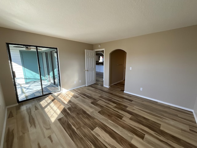 unfurnished room with wood-type flooring, a textured ceiling, and ceiling fan