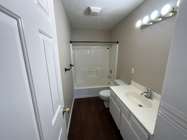 full bathroom featuring vanity, shower / tub combination, hardwood / wood-style flooring, toilet, and a textured ceiling