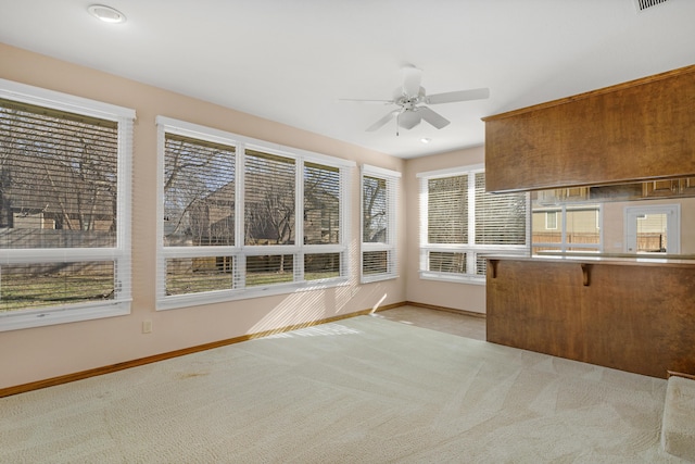 unfurnished sunroom with ceiling fan