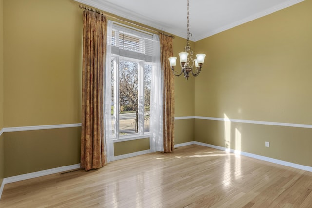 unfurnished room with light hardwood / wood-style flooring, ornamental molding, and an inviting chandelier