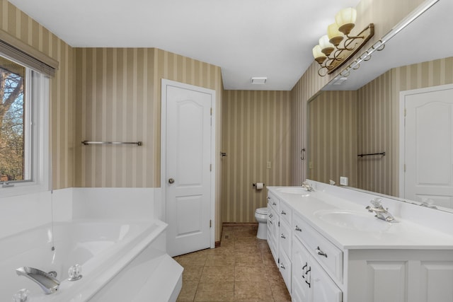 bathroom featuring tile patterned floors, vanity, toilet, and a tub