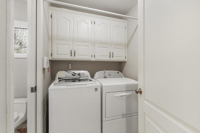 laundry room with washer and dryer and cabinets