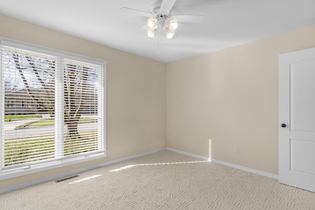 carpeted empty room featuring a wealth of natural light and ceiling fan