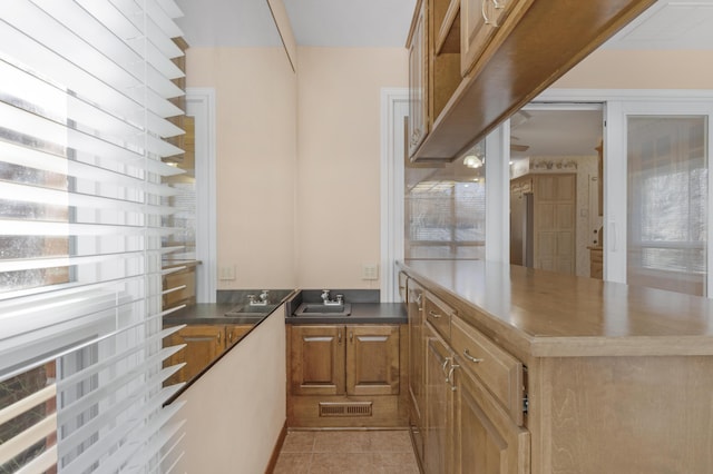 kitchen with plenty of natural light, light tile patterned floors, and sink