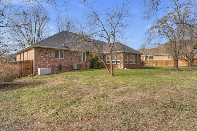 rear view of house featuring a yard and cooling unit