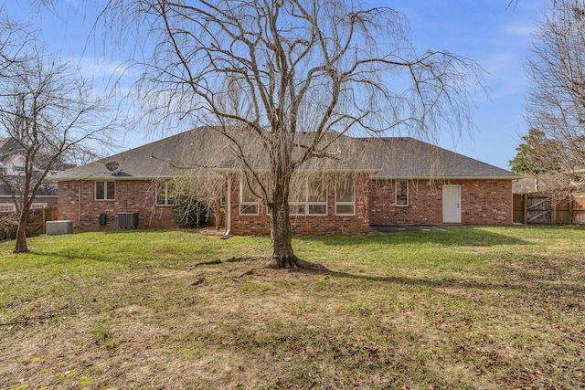 back of property featuring a lawn and central air condition unit