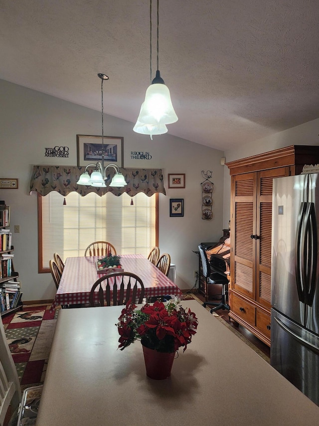 dining space with a notable chandelier, lofted ceiling, and a textured ceiling