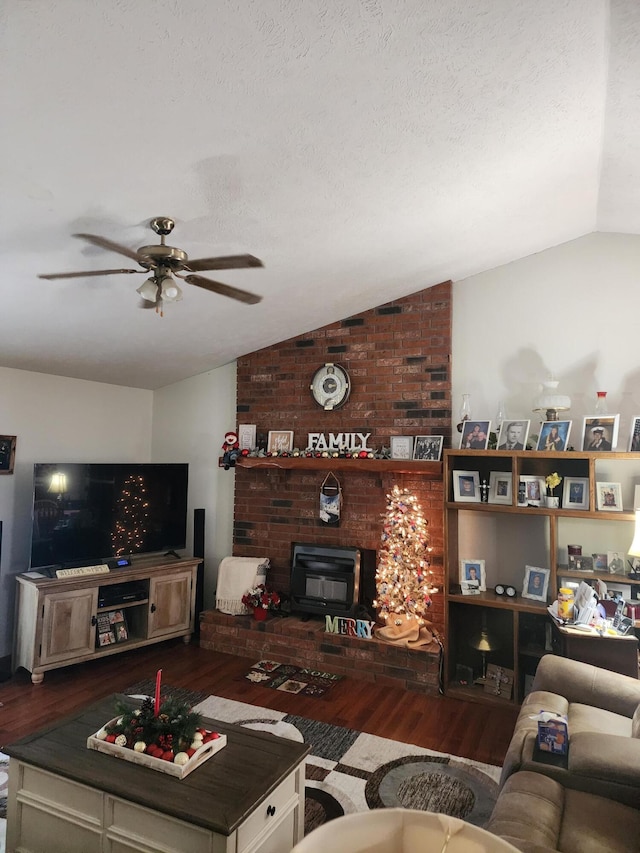 living room with hardwood / wood-style flooring, a wood stove, a textured ceiling, and vaulted ceiling