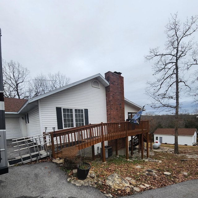 rear view of house featuring a wooden deck and central AC