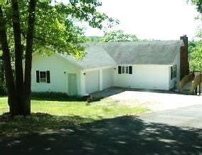 view of front of home featuring concrete driveway and a chimney