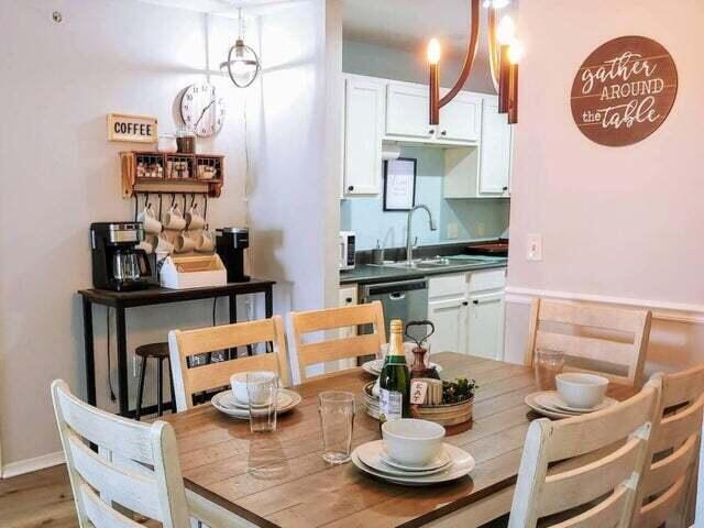 dining space with sink, wood-type flooring, and a notable chandelier