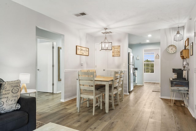 dining space featuring hardwood / wood-style floors and a notable chandelier