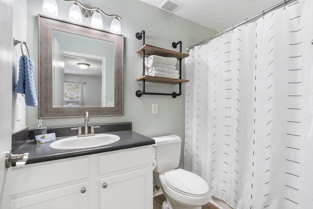 bathroom featuring a shower with curtain, vanity, a textured ceiling, and toilet