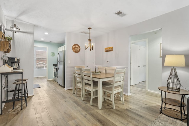 dining room featuring light hardwood / wood-style flooring and an inviting chandelier