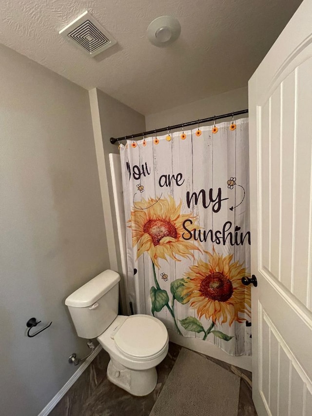 bathroom with a textured ceiling and toilet