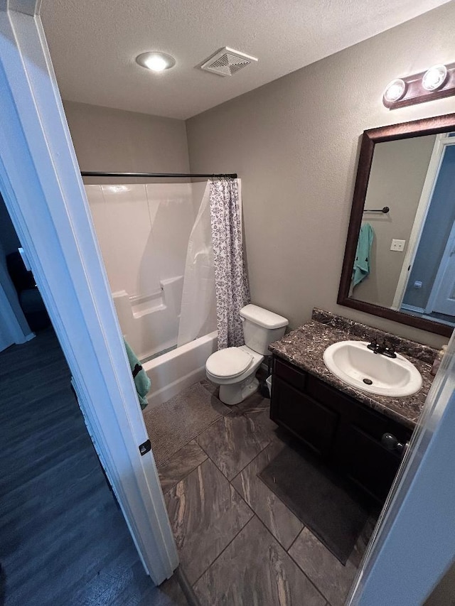 full bathroom with toilet, vanity, shower / tub combo with curtain, and a textured ceiling