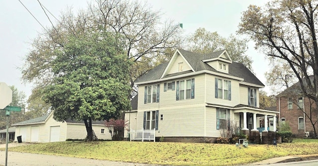 view of front of house with a detached garage and a front yard